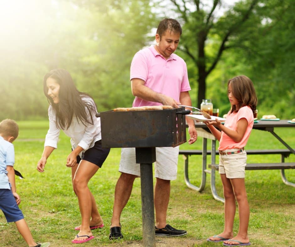 A family grills at a picnic area.