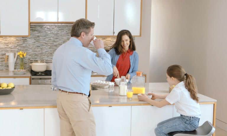 Family in kitchen eating breakfast