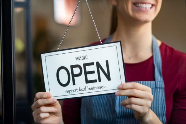 Woman with open for business sign