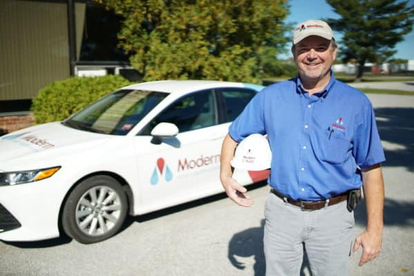 Pest control professional in front of car