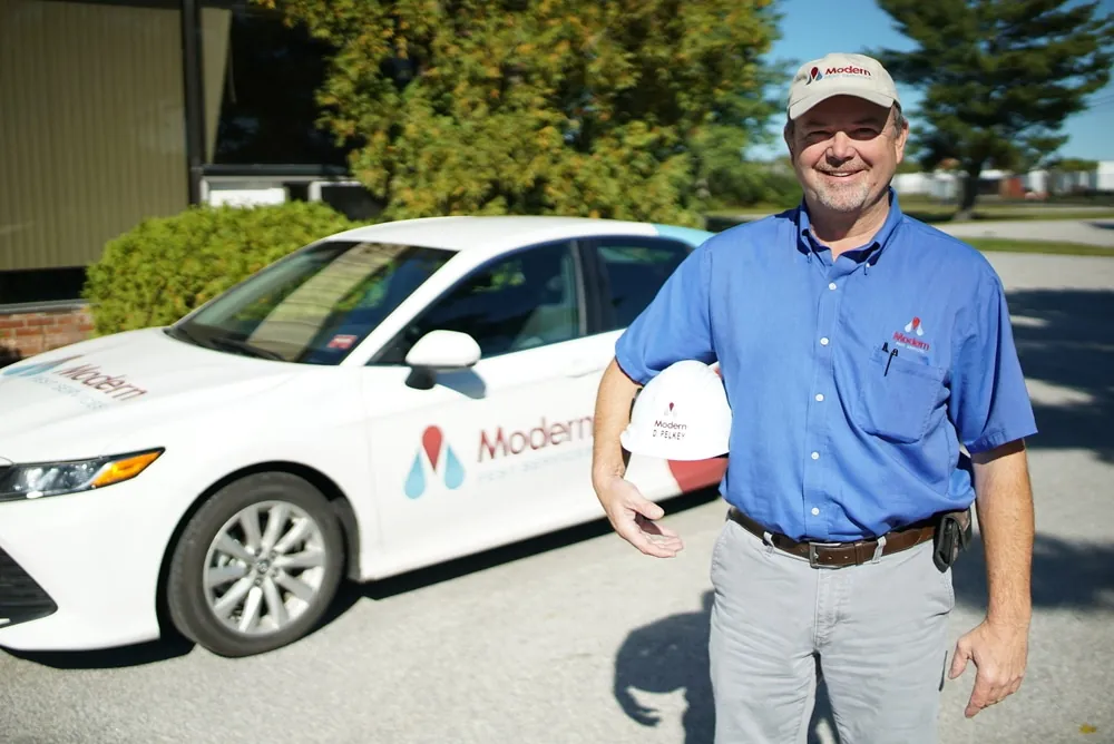 Pest control professional in front of car